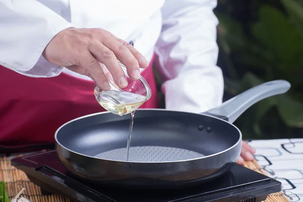 Chef versando olio vegetale nella padella — Foto Stock