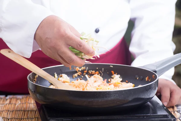 Chef colocando brotos de feijão e vazamento para a panela — Fotografia de Stock