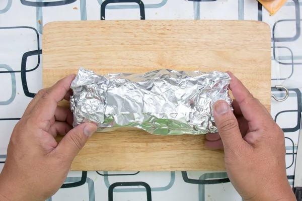 Envelopper le pain à la saucisse avec du papier aluminium — Photo