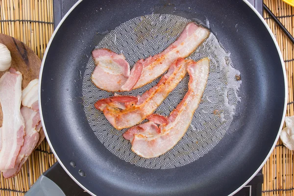 Chef frying bacon in the pan — Stock Photo, Image