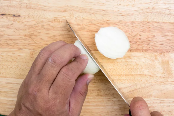 Chef slicing onion on wooden broad — Stock Photo, Image