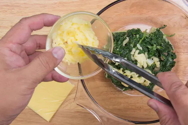 Poner queso en un tazón de espinacas — Foto de Stock
