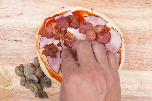 Putting Bacon on pizza crust — Stock Photo, Image