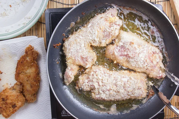 Chef-kok diepe gebakken varkensvlees in de pan — Stockfoto