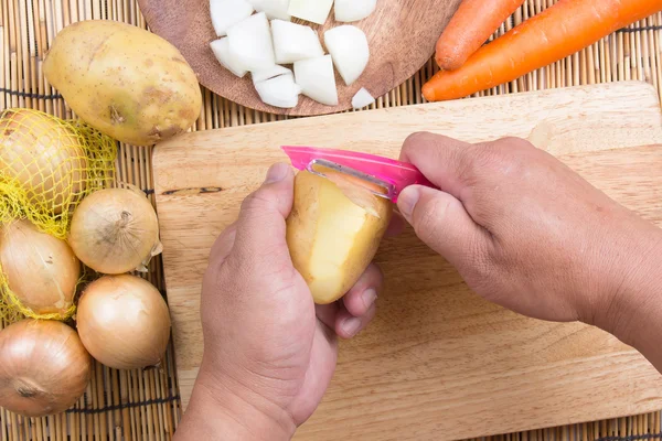 Chef mengupas kentang dengan pisau — Stok Foto