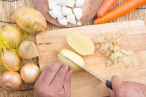 Kuchař, řezání brambor s nožem — Stock fotografie