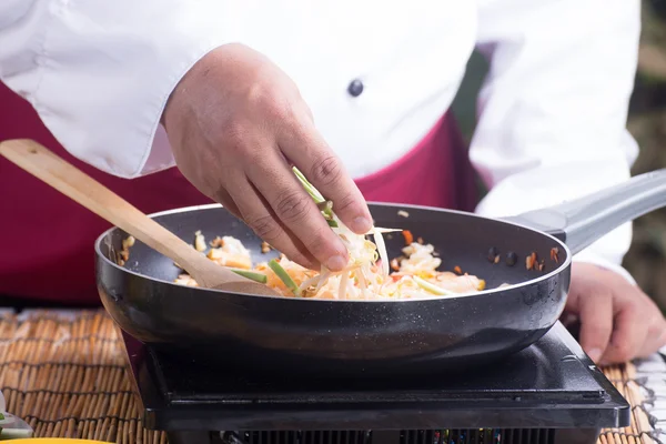 Chef putting bean sprouts and leek to the pan — Stock Photo, Image