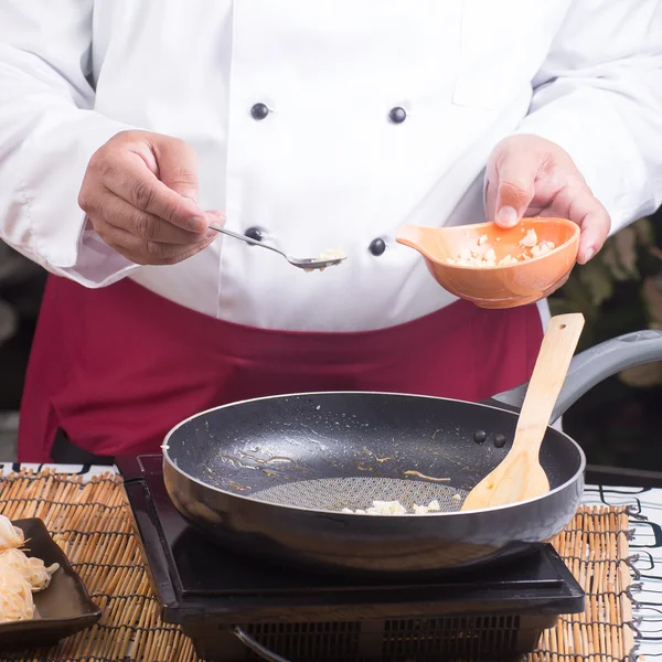 Kuchař, uvedení mleté česnek pro vaření Pad Thai — Stock fotografie