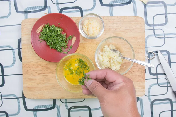 Kocken matlagning toppning korv bröd med pasley — Stockfoto