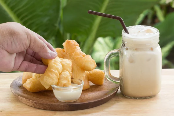 Hand holding deep fried dough stick — Stock Photo, Image