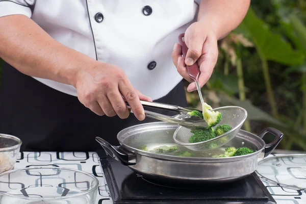 Koch brüht Brokkoli mit heißem Wasser — Stockfoto
