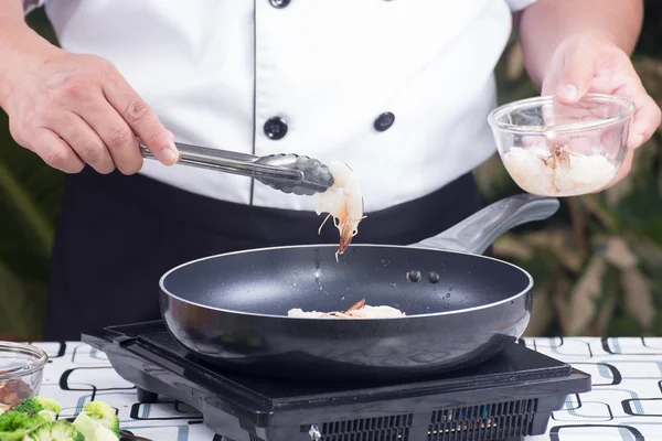 Chef-kok brengen garnalen in de pan — Stockfoto
