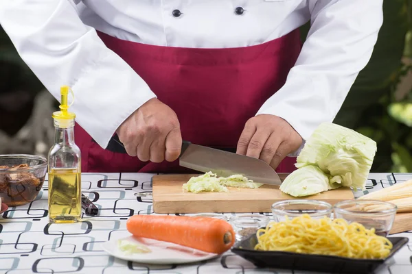 Koch schiebt Kohl auf Holzbrett — Stockfoto