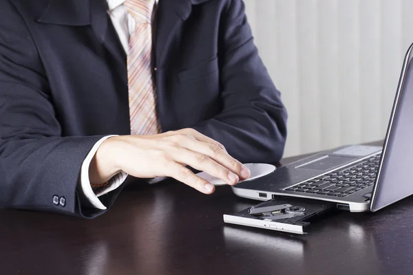 Affärsman som håller disken infoga till laptop — Stockfoto