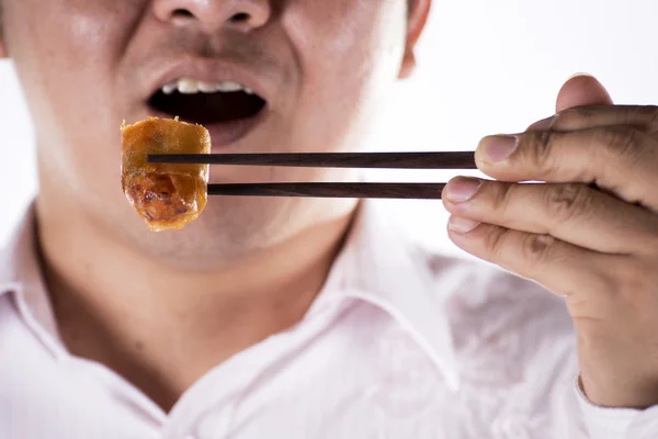 Un homme avec des baguettes mange des oeufs saupoudrer — Photo