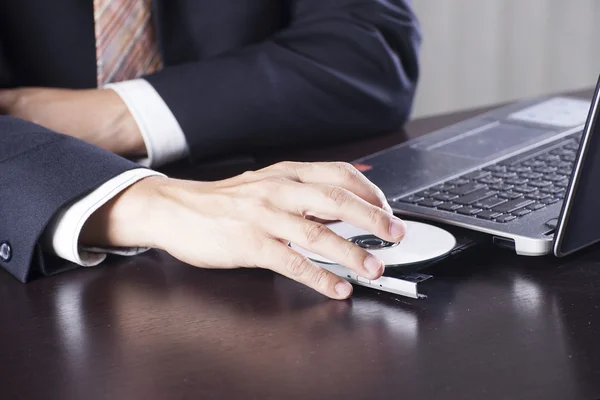 Business man insert disk to laptop — Stock Photo, Image