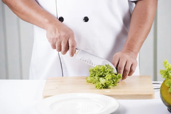 Кухарські руки розрізають салат — стокове фото