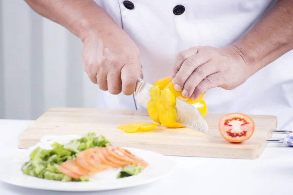 Руки шеф-кухаря розрізають жовтий болгарський перець — стокове фото