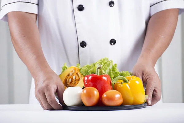 Szakács tartja a zöldség tálca — Stock Fotó