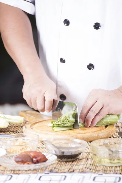 Шеф-повар режет овощи перед приготовлением лапши — стоковое фото