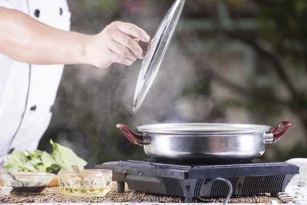 麺を調理する前に鍋の蓋を開けるシェフ — ストック写真