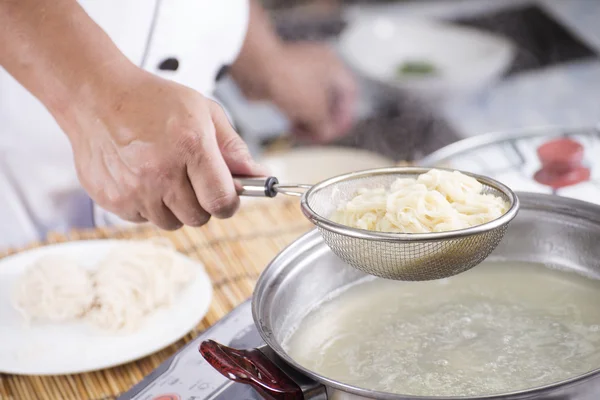 シェフの調理麺のザルを保持 — ストック写真