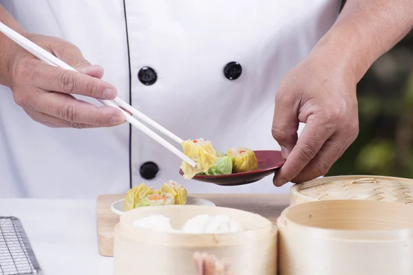 Koch mit Essstäbchen hält chinesischen Knödel — Stockfoto