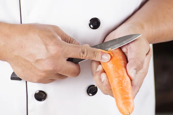 Chef is peeling carrots — Stock Photo, Image