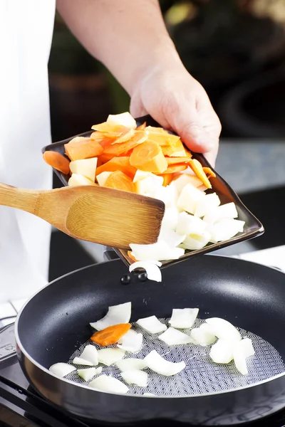 Шеф-кухар кладе овочі на сковороду для приготування японського свинячого каррі — стокове фото