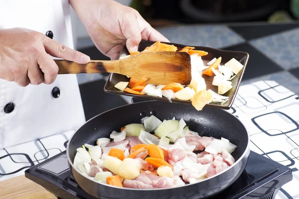 Koch setzt Karotte und rohe Kartoffeln zum Kochen japanischer Schweinekur ein — Stockfoto