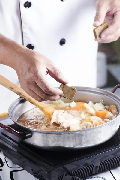 Chef colocando pasta de curry japonês para cozinhar — Fotografia de Stock