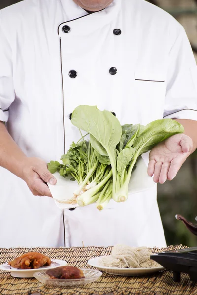 Шеф-кухар представляє овочі з інгредієнтом локшини — стокове фото