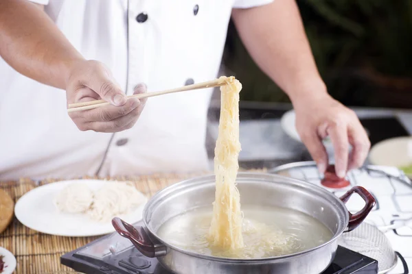 Chef tenendo la tagliatella dalla pentola con le bacchette — Foto Stock