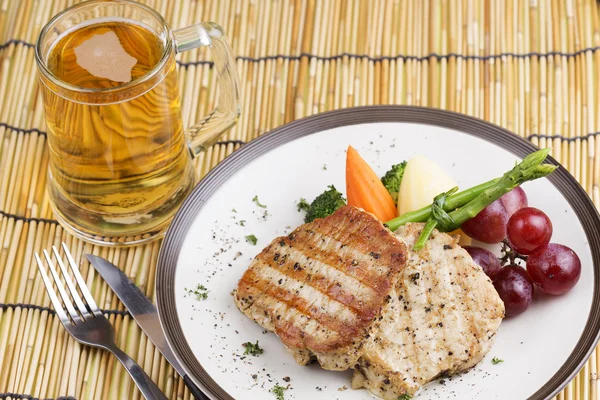 Schweinesteak und Bier — Stockfoto