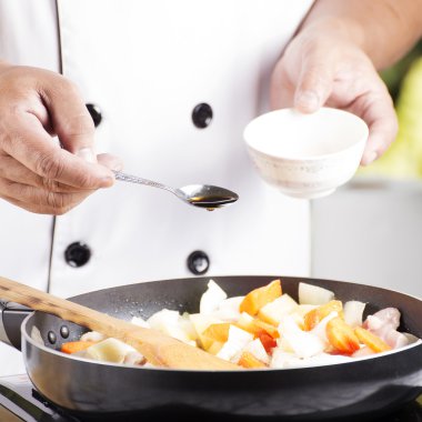 Japon por pişirme için pan için baharat sosu koyarak Şef