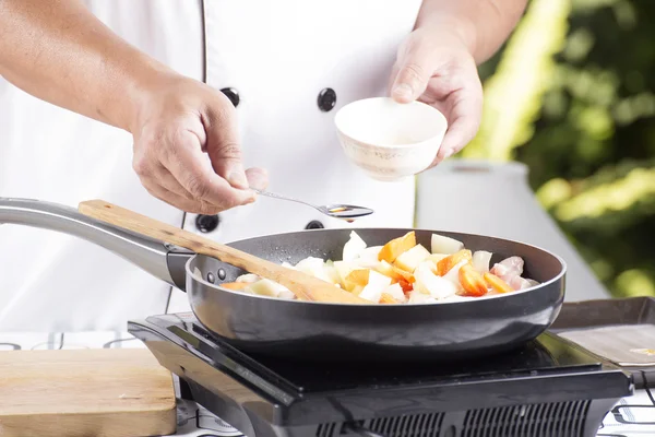 Kokki laittaa maustekastike pannulla ruoanlaittoon Japanilainen por — kuvapankkivalokuva