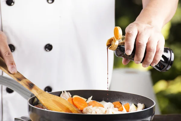 Chef-kok gieten shoyu saus aan de pan voor het koken van Japanse varkensvlees cu — Stockfoto