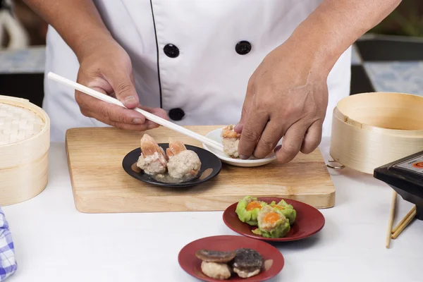 Chef usando palillos sostienen albóndigas chinas —  Fotos de Stock