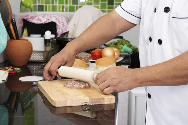 Chef poniendo pimienta a la hamburguesa de carne — Foto de Stock