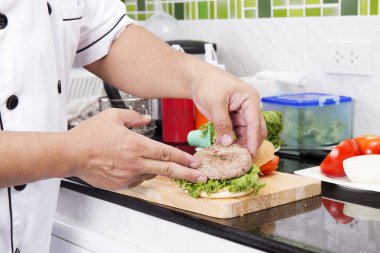Sığır eti hamburger çörek koyarak Şef