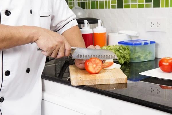 Mãos de Chef cortando Tomate — Fotografia de Stock