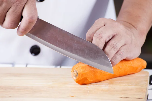 Chef is peeling carrots — Stock Photo, Image