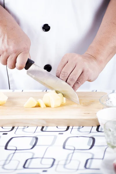 Koch schneidet Kartoffeln auf Holz breit — Stockfoto