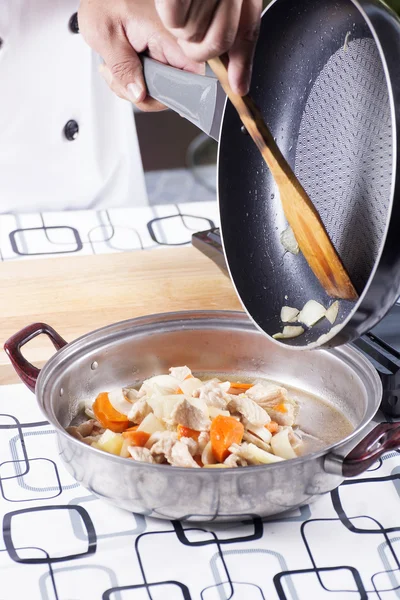 Chef colocando mexa frito caril de porco japonês para o pote — Fotografia de Stock