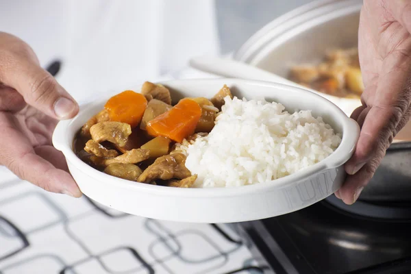 Chef putting stir fried Japanese pork curry to the pot