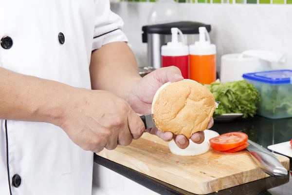 Chef triturar bollo hamburguesa con cuchillo — Foto de Stock