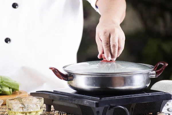麺を調理する前に鍋の蓋を開けるシェフ — ストック写真