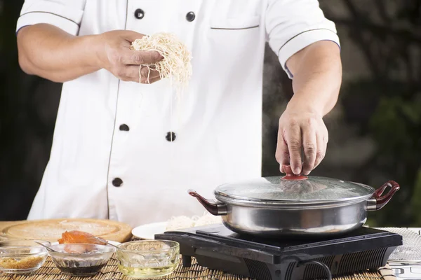 Chef segurando o macarrão antes de cozinhar — Fotografia de Stock