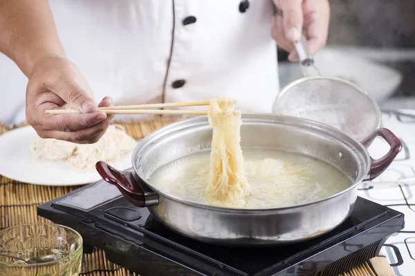 Chef segurando o macarrão do pote com pauzinhos — Fotografia de Stock