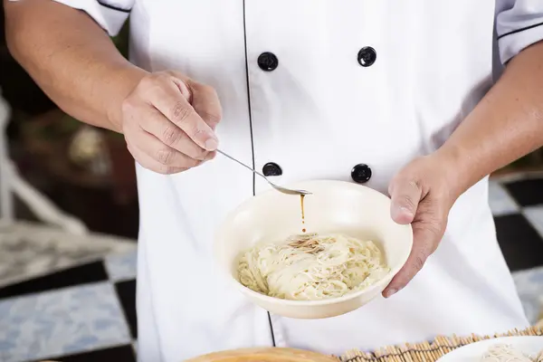 Chef cozinhar macarrão com molho de tempero — Fotografia de Stock